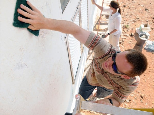 DJIBOUTI (CJTF-HOA PAO) -- Navy Petty Officer 3rd Class Gabriel Zisk scrubs the walls of a local school during a Community Assistance Volunteer project in which servicemembers and civilians assigned to Camp Lemonnier began preparing the school for painting.  Volunteers spent about four hours March 26 cleaning the Nagad School's exterior, which will eventually receive a fresh coat of blue and white paint.  (U.S. Air Force photo/Staff Sgt. Austin M. May)