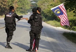 A Malaysian flag is removed by security forces in southern Thailand.
