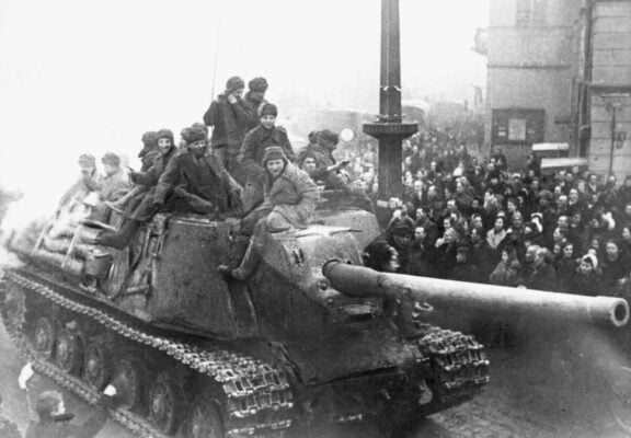 A Soviet tank destroyer transports Soviet troops liberating cities and camps during World War II