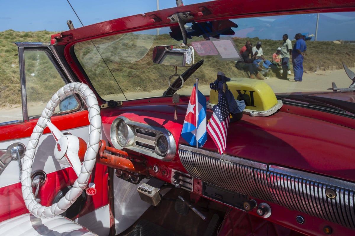 The stars and stripes and the Cuban national flag are placed together on the dashboard of a vintage American convertible in Havana, Cuba, Thursday, Feb. 18, 2016. President Barack Obama said that he will visit Cuba on March 21-22, making him the first sitting president in more than half a century to visit the island nation. (AP Photo/Desmond Boylan)