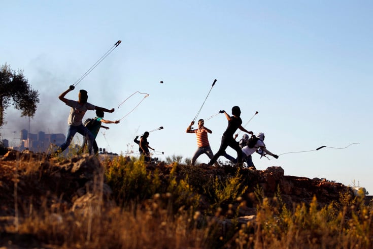 Palestinian protesters hurl rocks at Israeli soldiers during clashes in Betunia, near the West Bank city of Ramallah October 11, 2013. REUTERS/Mohamad Torokman (WEST BANK - Tags: POLITICS CIVIL UNREST TPX IMAGES OF THE DAY)