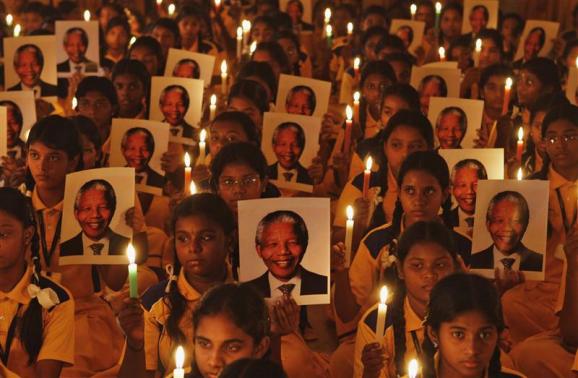 Schoolchildren hold candles and portraits of former South African President Nelson Mandela during a prayer ceremony at a school in the southern Indian city of Chennai December 6, 2013. REUTERS/Babu