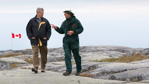 PM Harper is given a tour of Cape Merry Historical Site in Churchill by a Parks Canada presenter. © Sean Kilpatrick / The Canadian Press