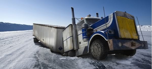 An ice road collapses beneath a truck.