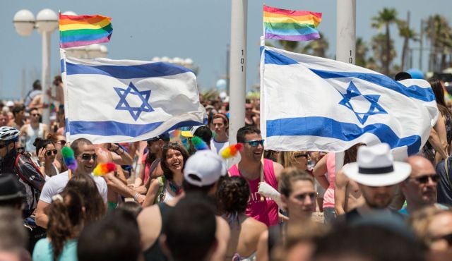 Participants wave Israeli's flags during the 2014 annual gay pride parade in Tel Aviv. (AFP)