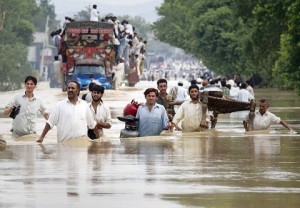 Residents carry their belongings through a flooded road in Risalpur, located in Nowshera District, in Pakistan's Northwest Frontier Province July 30, 2010.